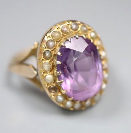 An early 20th century 9ct, amethyst and split pearl set oval dress ring, size N, gross 4.8 grams, (one pearl missing).